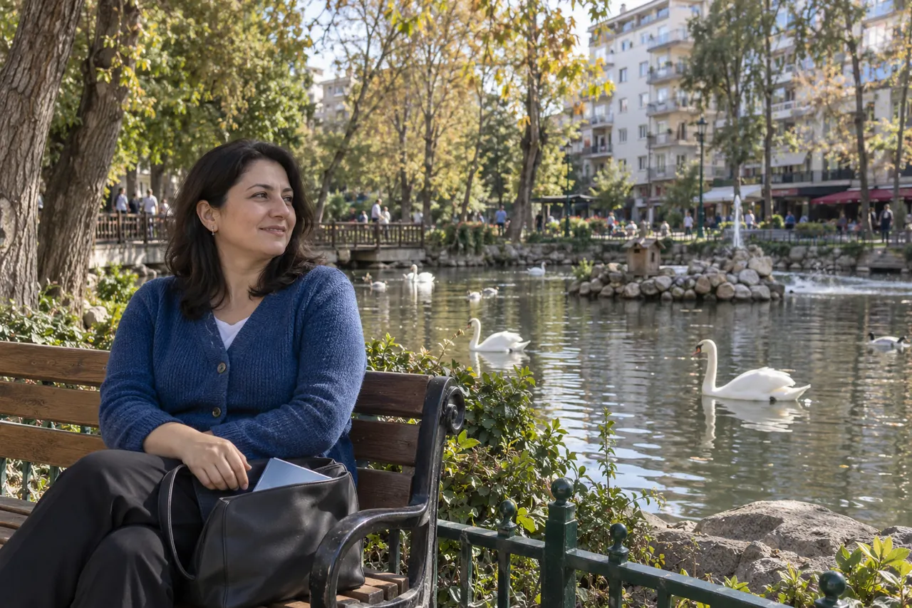 Ankara Kuğulu Park’ta bir kadın, kuğuların bulunduğu göletin yanındaki bankta oturuyor.