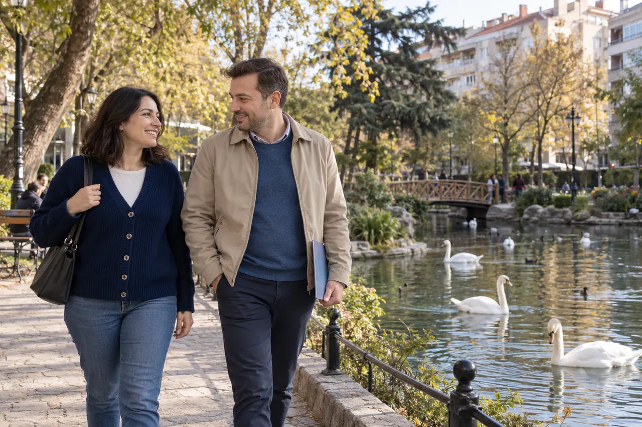 An adult couple walk beside the swan pond at Kugulu Park in Ankara.